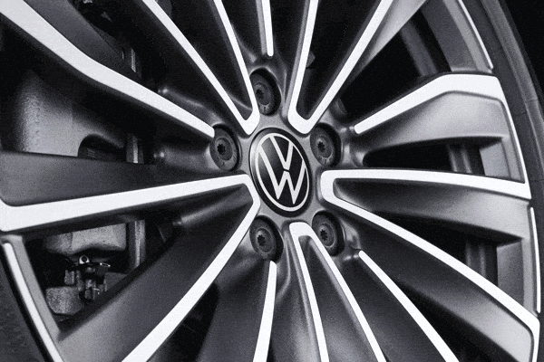 Silberne Leichtmetallfelge in Bewegung mit ruhig stehendem VW Logo der Nabenkappe, 10A071213A